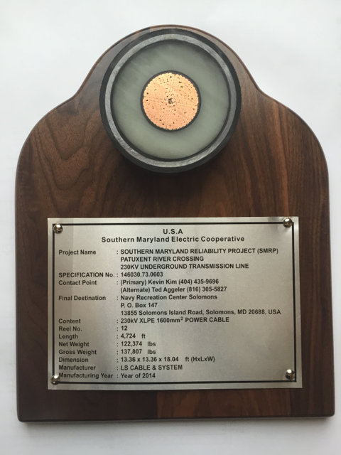A wooden plaque displaying a cross-section of a power cable and a detailed information plate about the Southern Maryland Electric Cooperative project for a 230kV underground transmission line.