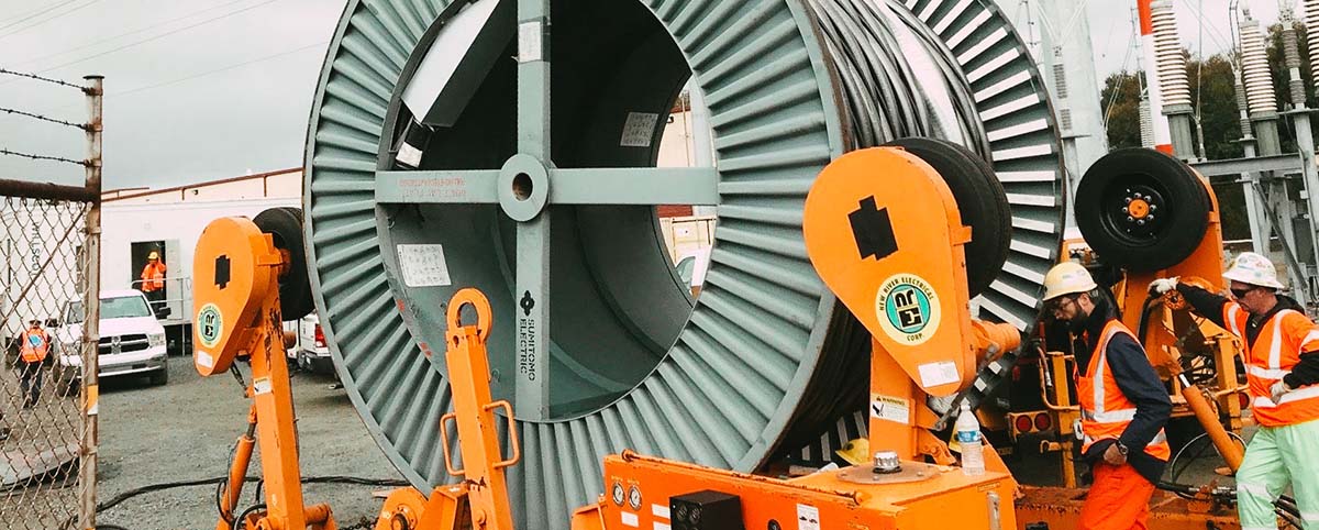 Two NRE employees working with a cable reel at a project in San Bruno, Ca.