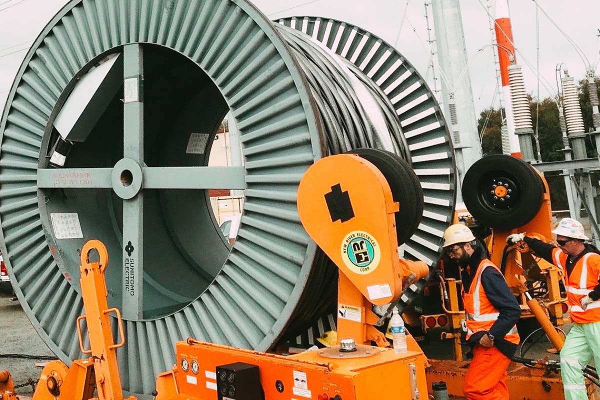 A large cable reel with New River Electrical employees in San Bruno, California.