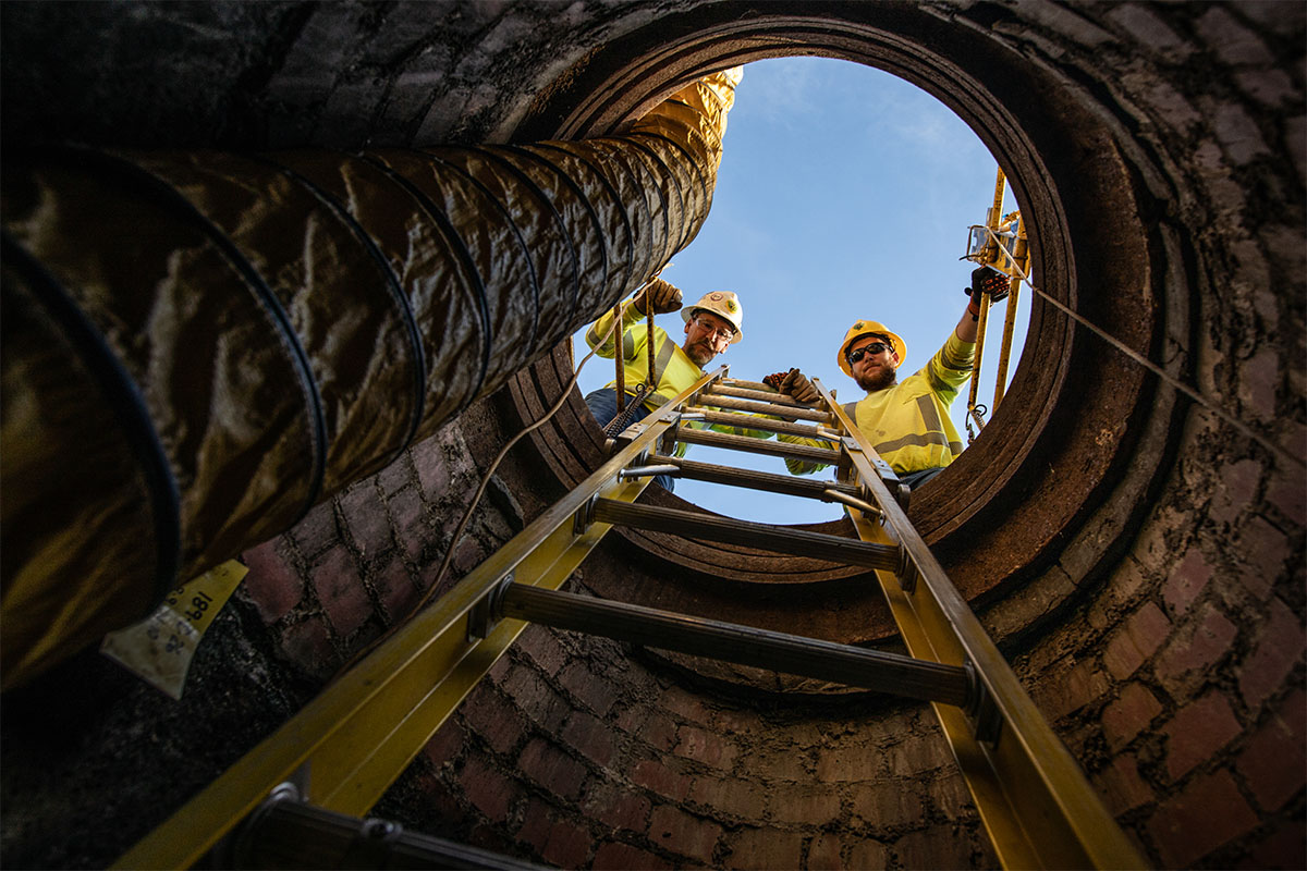 New River Electrical Employees looking down a manhole.