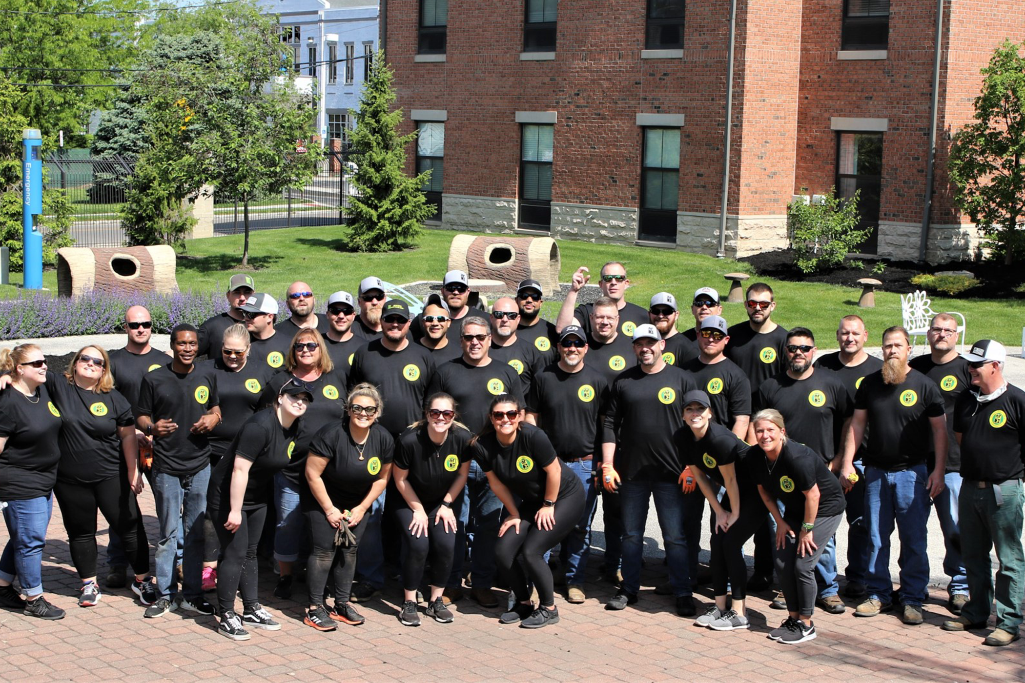 A large group of folks wearing New River Electrical shirts posing for a group photo