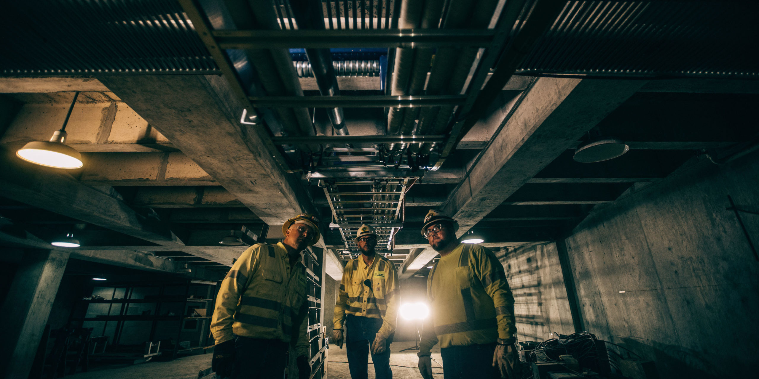 Three New River Electrical employees working in a underground station.