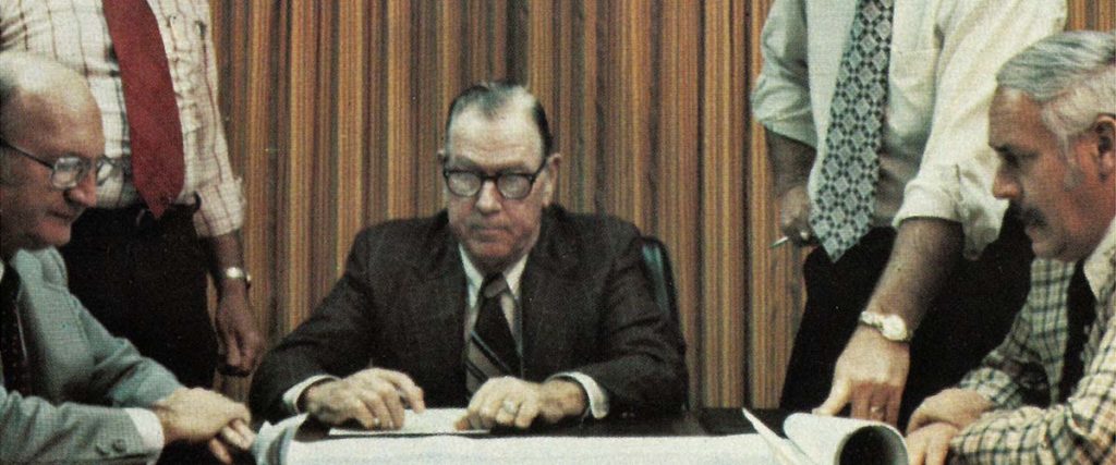 New River Electrical's Board fo Directors sitting at a table in a meeting in the 1960s/70s