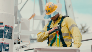An NRE worker adjusting their harness